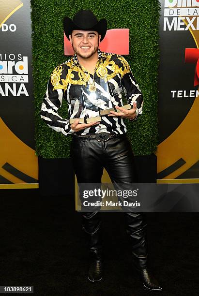 Singer Gerardo Ortiz poses in the pressroom with the awards for Male Artist of the year, Songs Artist of the year, Norteno Artist of the year and...