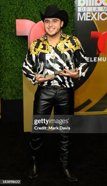 Singer Gerardo Ortiz poses in the pressroom with the awards for Male Artist of the year, Songs Artist of the year, Norteno Artist of the year and...