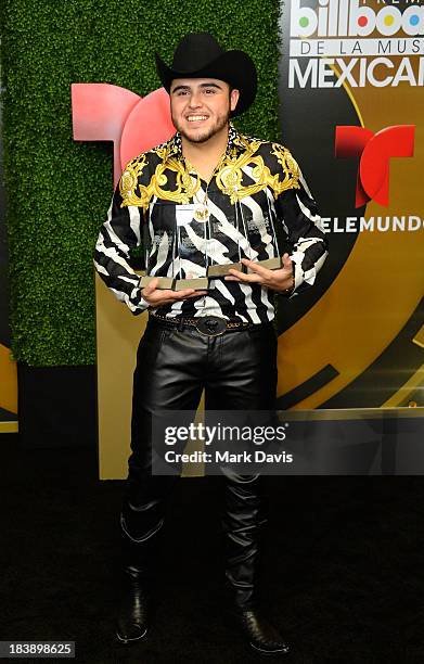 Singer Gerardo Ortiz poses in the pressroom with the awards for Male Artist of the year, Songs Artist of the year, Norteno Artist of the year and...