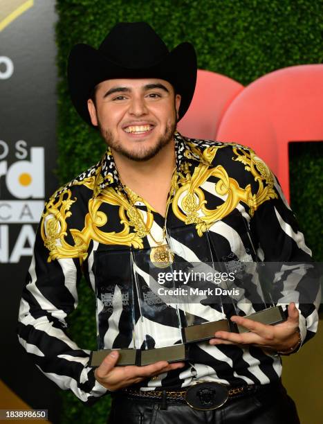 Singer Gerardo Ortiz poses in the pressroom with the awards for Male Artist of the year, Songs Artist of the year, Norteno Artist of the year and...