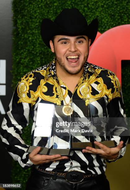 Singer Gerardo Ortiz poses in the pressroom with the awards for Male Artist of the year, Songs Artist of the year, Norteno Artist of the year and...