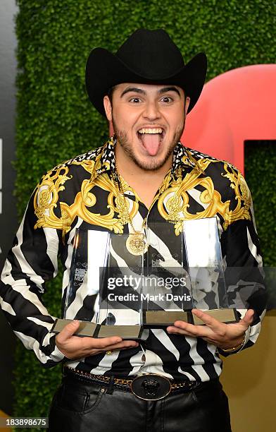 Singer Gerardo Ortiz poses in the pressroom with the awards for Male Artist of the year, Songs Artist of the year, Norteno Artist of the year and...