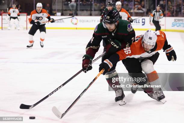 Matt Dumba of the Arizona Coyotes attempts to control the puck under pressure from Joel Farabee of the Philadelphia Flyers during the first period of...