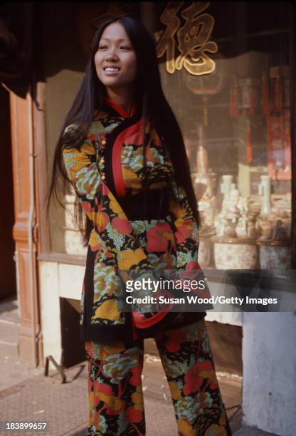 Portrait of an unidentified model dressed in a two-piece, print trouser suit as she poses on the streets of Manhattan's Chinatown, New York, New...