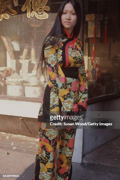 Portrait of an unidentified model dressed in a two-piece, print trouser suit as she poses on the streets of Manhattan's Chinatown, New York, New...