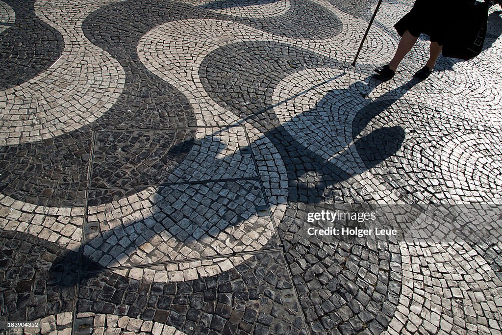 Shadow of elderly woman with walking cane