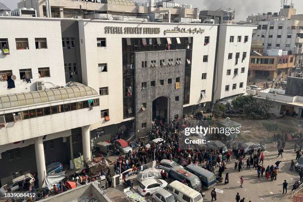 Displaced Palestinians gather in the yard of Gaza's Al-Shifa hospital on December 10 as battles continue between Israel and the militant group Hamas...
