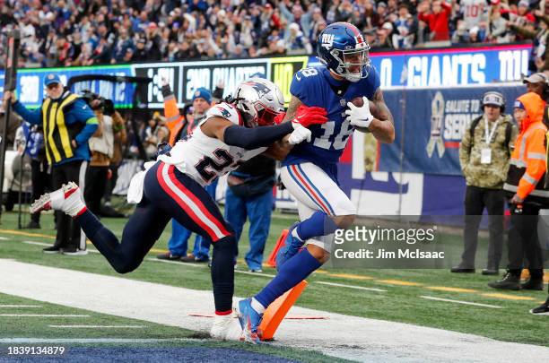 Isaiah Hodgins of the New York Giants runs in his touchdown against Kyle Dugger of the New England Patriots at MetLife Stadium on November 26, 2023...