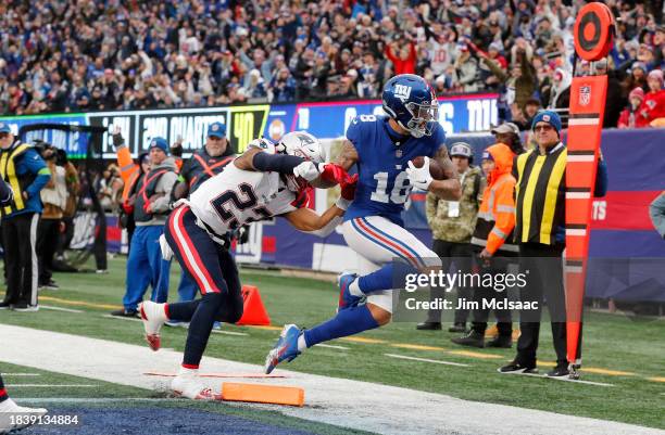 Isaiah Hodgins of the New York Giants runs in his touchdown against Kyle Dugger of the New England Patriots at MetLife Stadium on November 26, 2023...