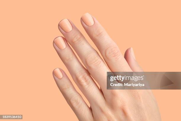 manicure in the colors of the year peach color. - industrie de la mode photos et images de collection