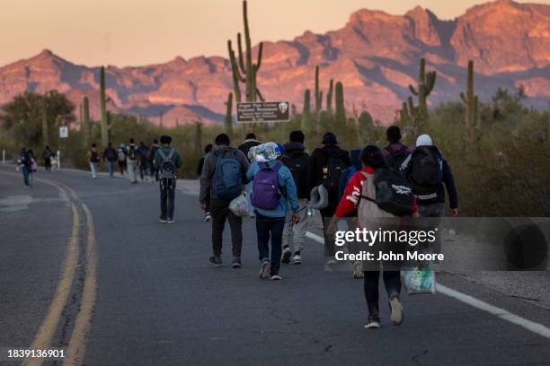 Immigrants walk into the United States after they crossed the U.S.-Mexico border on December 07, 2023 in Lukeville, Arizona. A surge of immigrants...