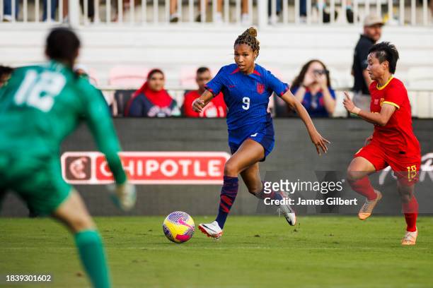 Midge Purce of the United States dribbles the ball against Zhang Linyan of China PR during the second half of a match at DRV PNK Stadium on December...