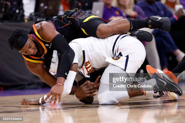 Josh Okogie of the Phoenix Suns and Reggie Jackson of the Denver Nuggets battle for a loose ball during the second half at Footprint Center on...