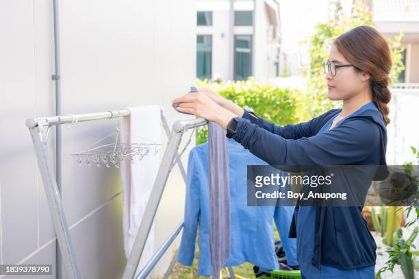 asian healthcare worker while hang up the laundry. - medical scrubs hanger stock pictures, royalty-free photos & images