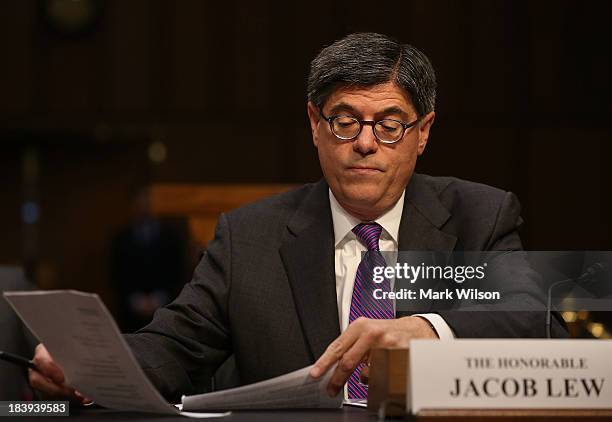 Treasury Secretary Jack Lew looks over his papers during a Senate Finance Committee hearing on Capitol Hill, October 10, 2013 in Washington, DC. The...