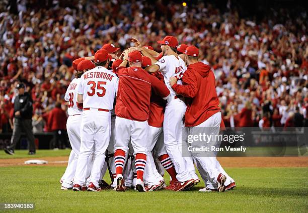 Members of the St. Louis Cardinals celebrate defeating the Pittsburgh Pirates in Game 5 to clinch the National League Division Series on Wednesday,...