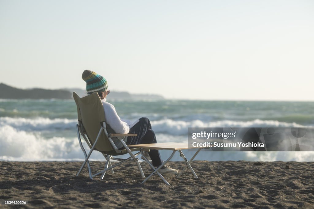 A woman enjoys day camping at a nearby beach.