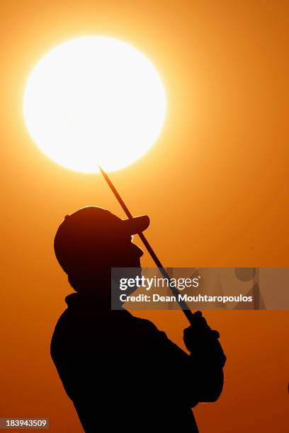 Thomas Aiken of South Africa looks on after he hit his practice shot on the driving range during the first round of the Portugal Masters at Oceanico...