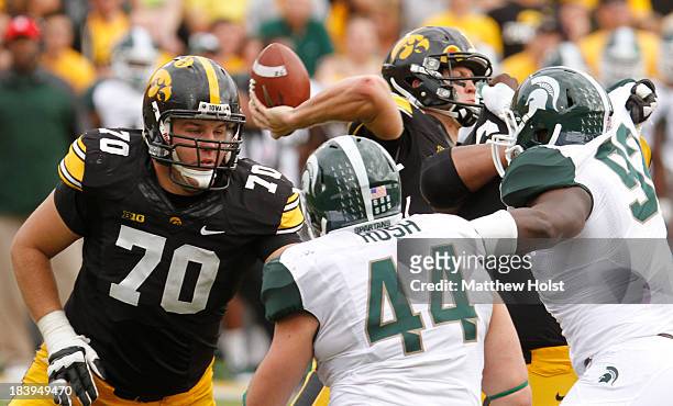 Offensive lineman Brett Van Sloten of the Iowa Hawkeyes works to defend quarterback Jake Rudock during the fourth quarter from defensive end Marcus...