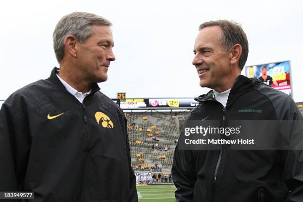 Head coach Kirk Ferentz of the Iowa Hawkeyes visits with head coach Mark Dantonio of the Michigan State Spartans before their match-up on October 5,...