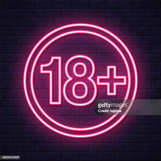 18+ eighteen plus sign - age restriction. glowing neon icon on brick wall background - number 18 stock illustrations