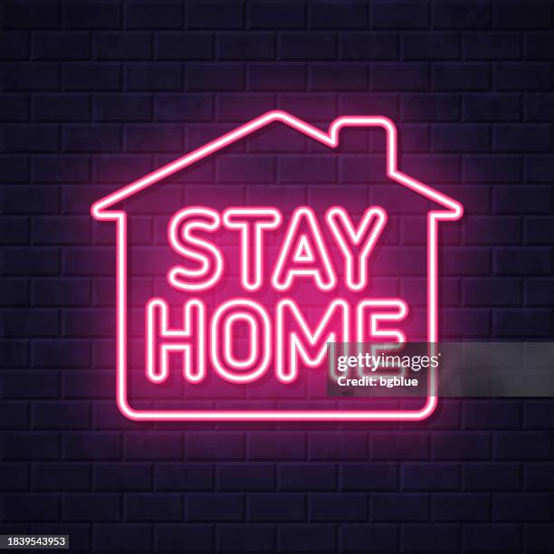stay home. glowing neon icon on brick wall background - brick wall interior stock illustrations