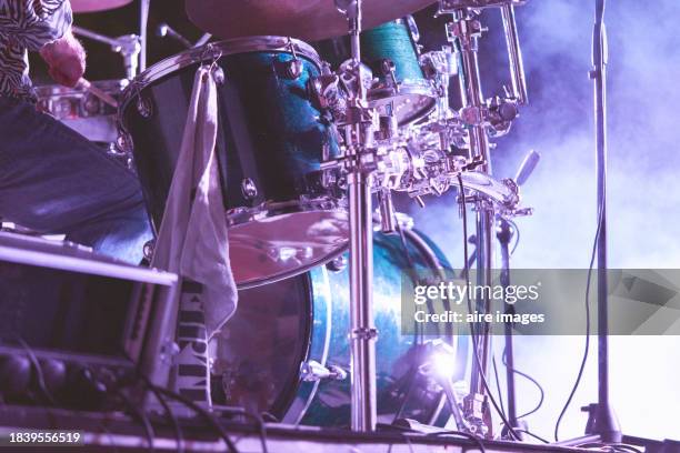 close-up of drum of a musical percussion instrument being touched by a person during a concert at night - tambour et batterie photos et images de collection