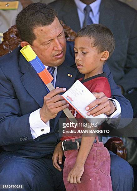 Venezuelan President Hugo Chavez, speaks to a young boy before the Youth Day Parade in La Victoria, Venezuela, 12 Febuary 2003. Hugo Chávez,...