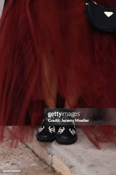 Karin Teigl seen wearing H&M Studio red ruffled tulle long bandeau dress and Chanel black logo rubber boots, on November 25, 2023 in Vienna, Austria.