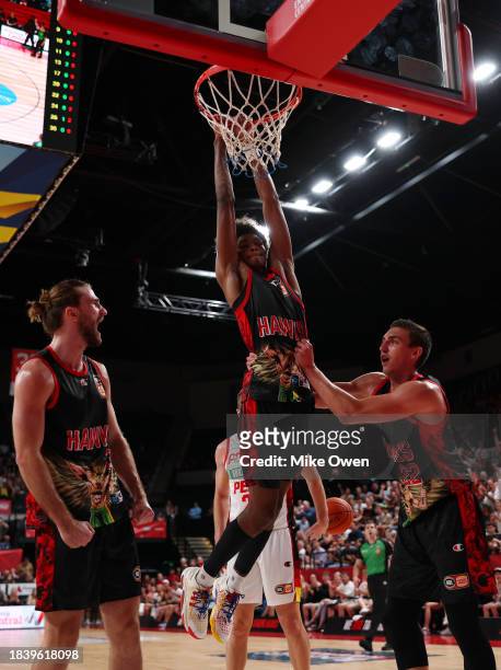 Johnson of the Hawks dunks as teammates Sam Froling and Mason Peatling of the Hawks celebrate during the round 10 NBL match between Illawarra Hawks...