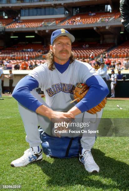 Pitcher Randy Johnson of the Seattle Mariners sits on a ball bag during batting practice prior to a Major League Baseball game against the Oakland...
