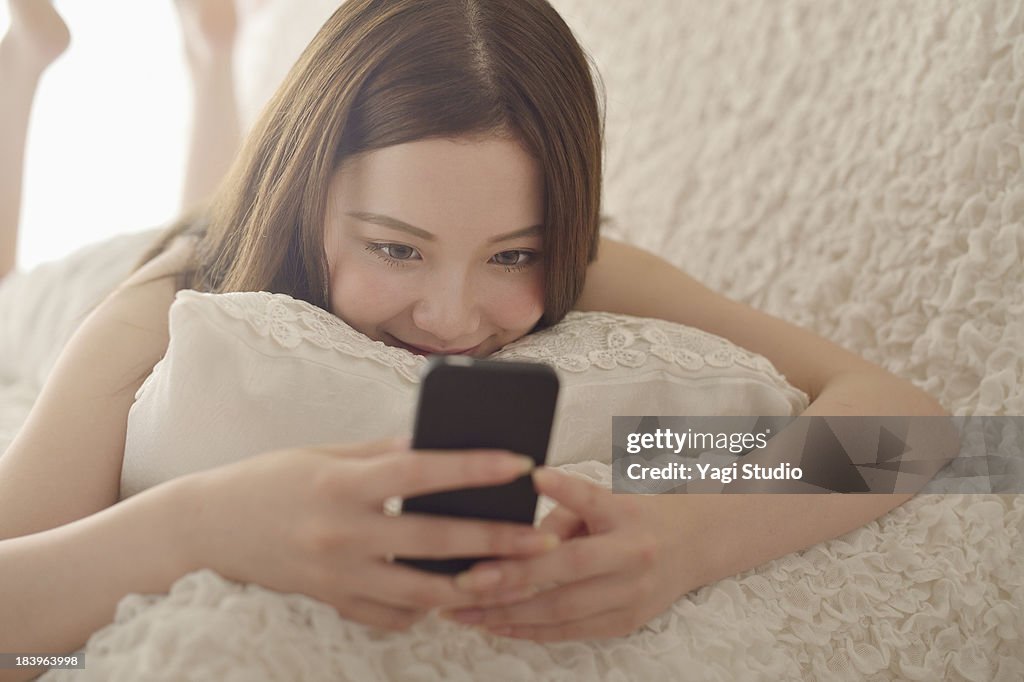 Women using Smartphone on the sofa.