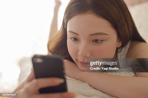 women using smartphone on the sofa. - スマートフォン ストックフォトと画像