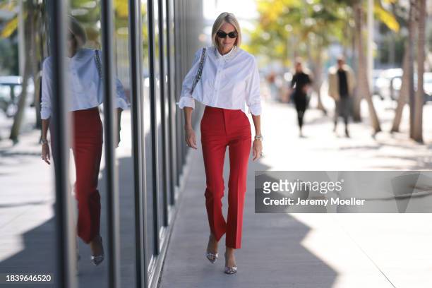 Lena Johnson seen wearing black sunglasses, silver earrings, white cotton cropped shirt / blouse with rhinestones pattern collar, red long pants,...