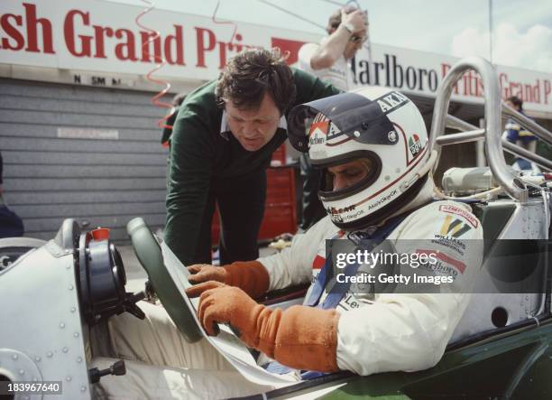 Alan Jones of Australia talks with technical director Patrick Head as he sits aboard the Albilad-Williams Racing Team Williams FW07B Ford V8 during...