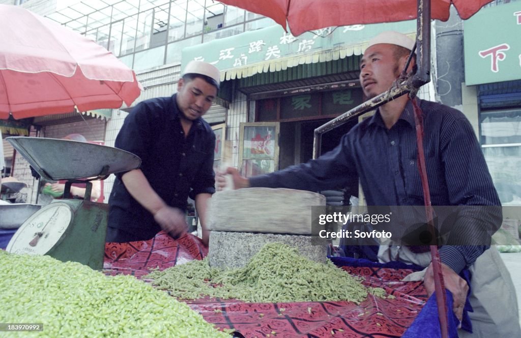 Muslim men preparing peas for sale at an outdoor market - Xining - Qinghai Province, China