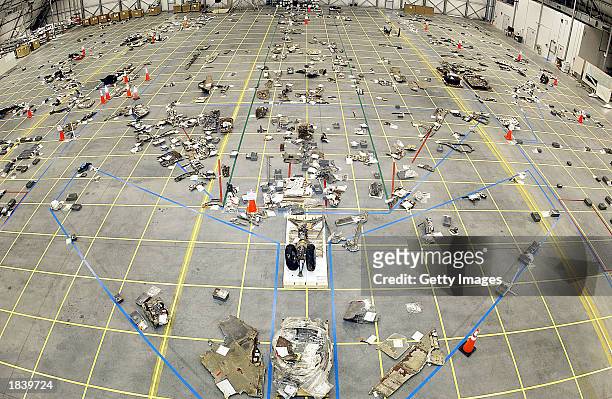 In this NASA handout photo, NASA crash investigators place debris from the Space Shuttle Columbia onto a grid on the floor of a hangar on March 7,...