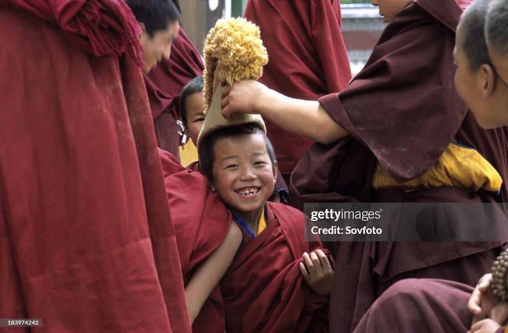 Tibetan Buddhist novice monks waiting outside for a ceremony to start - Tongren - Qinghai Province, China, Tibet