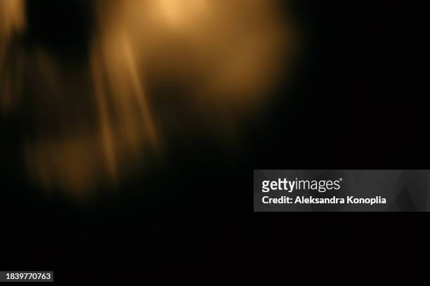 golden crystal rainbow light leak texture  effect  on black background - lense flare stock-fotos und bilder