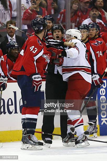 An official pulls apart Tom Wilson of the Washington Capitals and Brett Sutter of the Carolina Hurricanes during the first period at Verizon Center...