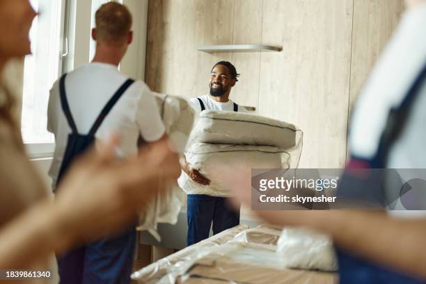male movers carrying furniture in the apartment. - moving service imagens e fotografias de stock