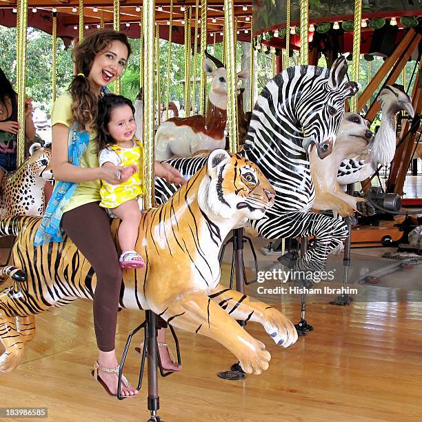 mother and daughter on on merry go round tiger - tiger girl stock pictures, royalty-free photos & images