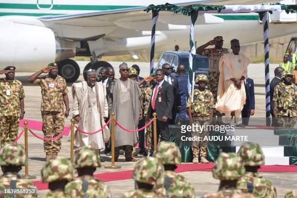 Nigerian President Bola Tinubu is saluted as he arrives at the Airforce Base in Maiduguri on December 11, 2023 for the start of the Chief of Army...