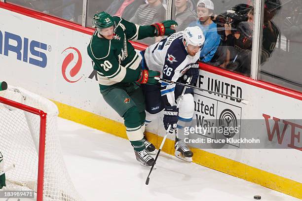Ryan Suter of the Minnesota Wild defends against Blake Wheeler of the Winnipeg Jets during the game on October 10, 2013 at the Xcel Energy Center in...