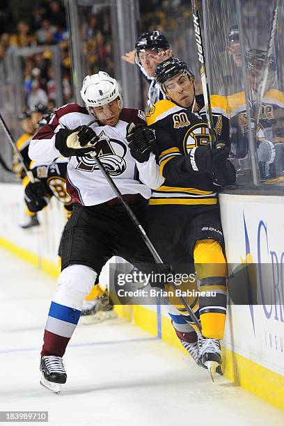 Jan Hejda of the Colorado Avalanche checks against Chris Kelly of the Boston Bruins at the TD Garden on October 10, 2013 in Boston, Massachusetts.