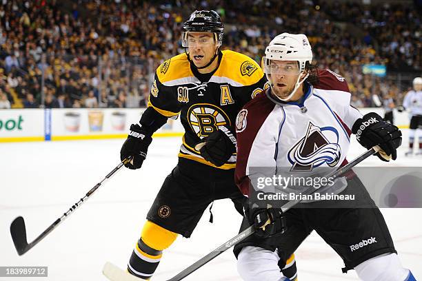 Chris Kelly of the Boston Bruins skates against Nate Guenin of the Colorado Avalanche at the TD Garden on October 10, 2013 in Boston, Massachusetts.