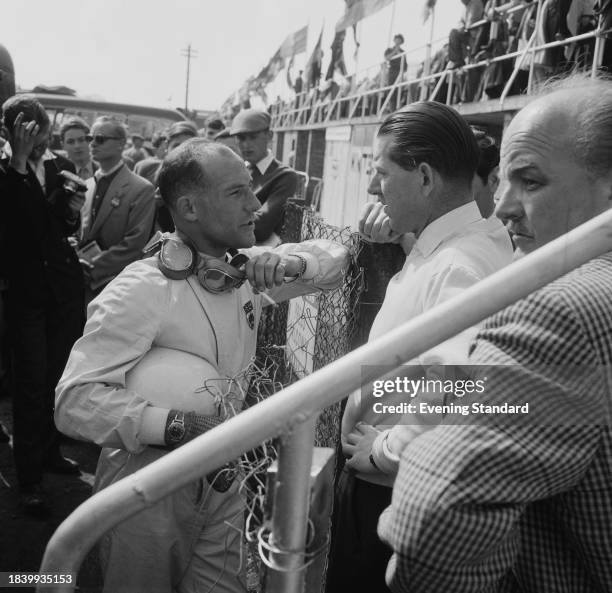 Stirling Moss talks to Rob Walker of Rob Walker Racing Team during the BRDC International Trophy Race, Silverstone circuit, Northamptonshire, May 3rd...