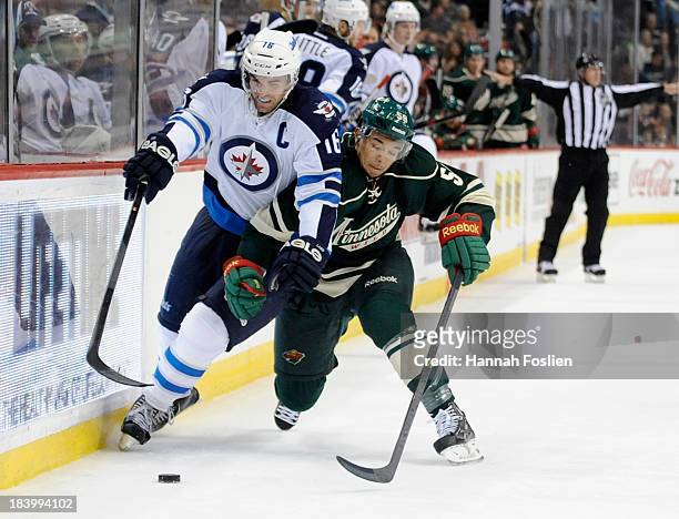 Andrew Ladd of the Winnipeg Jets and Mathew Dumba of the Minnesota Wild battle for the puck during the second period of the game on October 10, 2013...