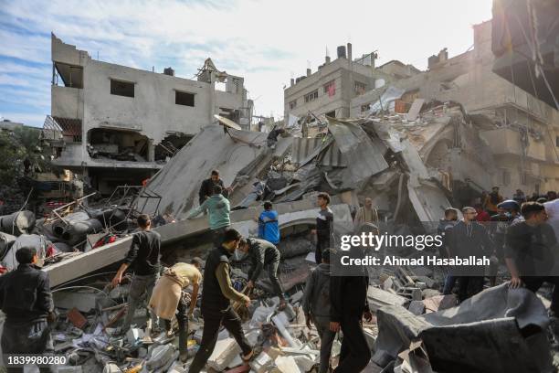 Palestinian citizens carry out search and rescue operations amid the destruction caused by Israeli air strikes on December 08, 2023 in Khan Yunis,...