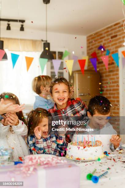 kinder haben spaß mit konfetti auf einer geburtstagsfeier - kindergeburtstag stock-fotos und bilder